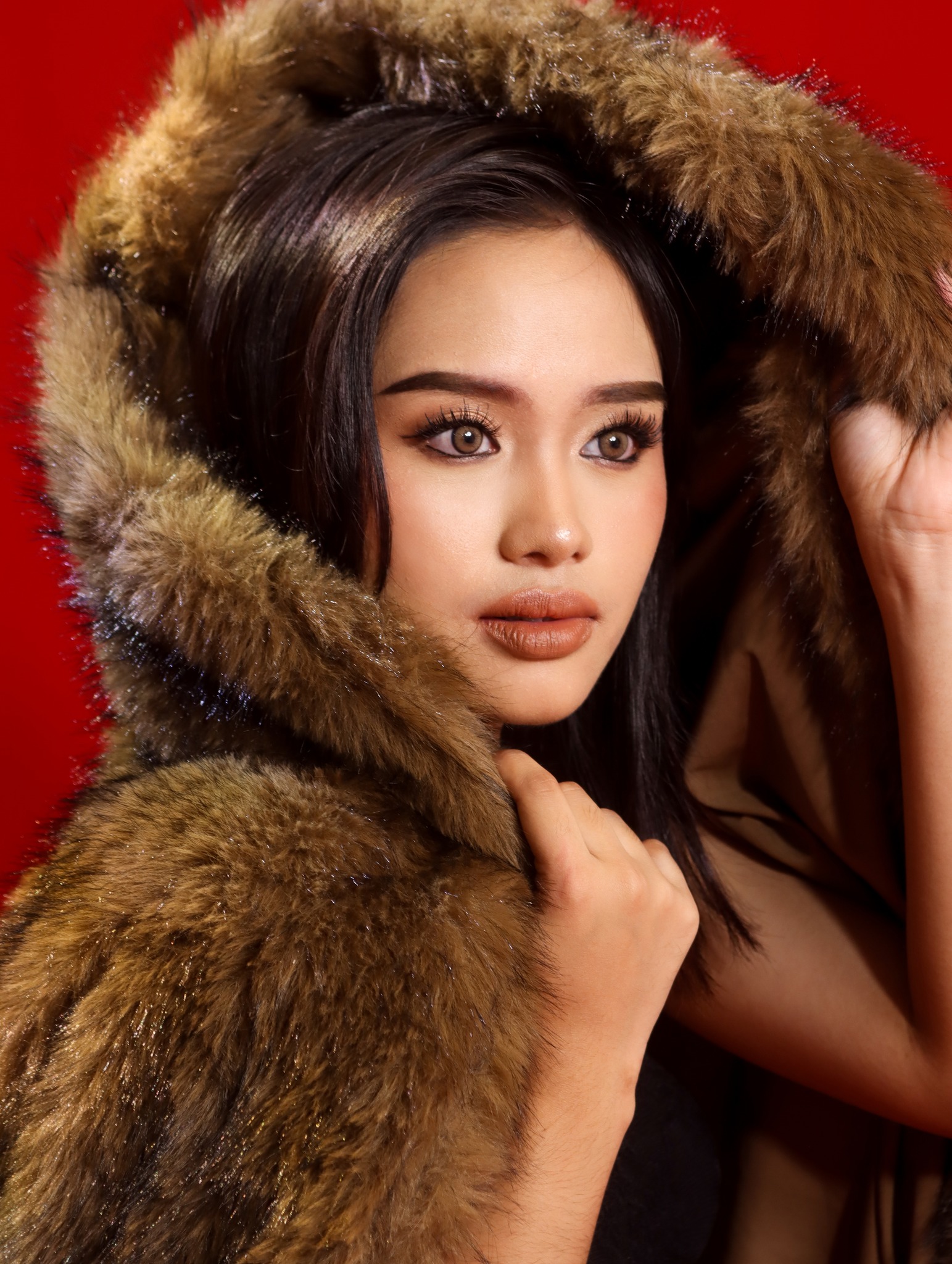 Glam close-up portrait on red backdrop