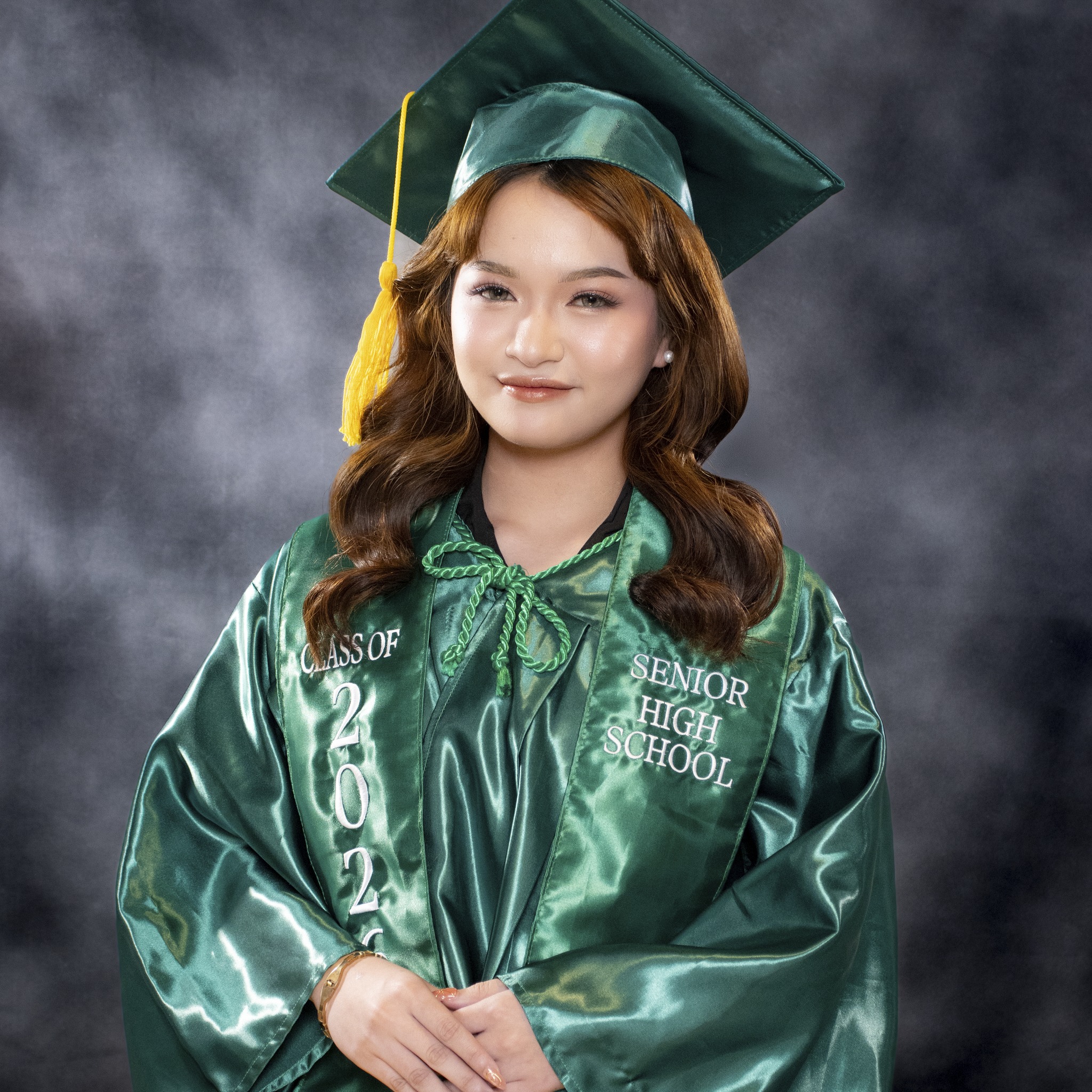 Graduation portrait in green cap and gown
